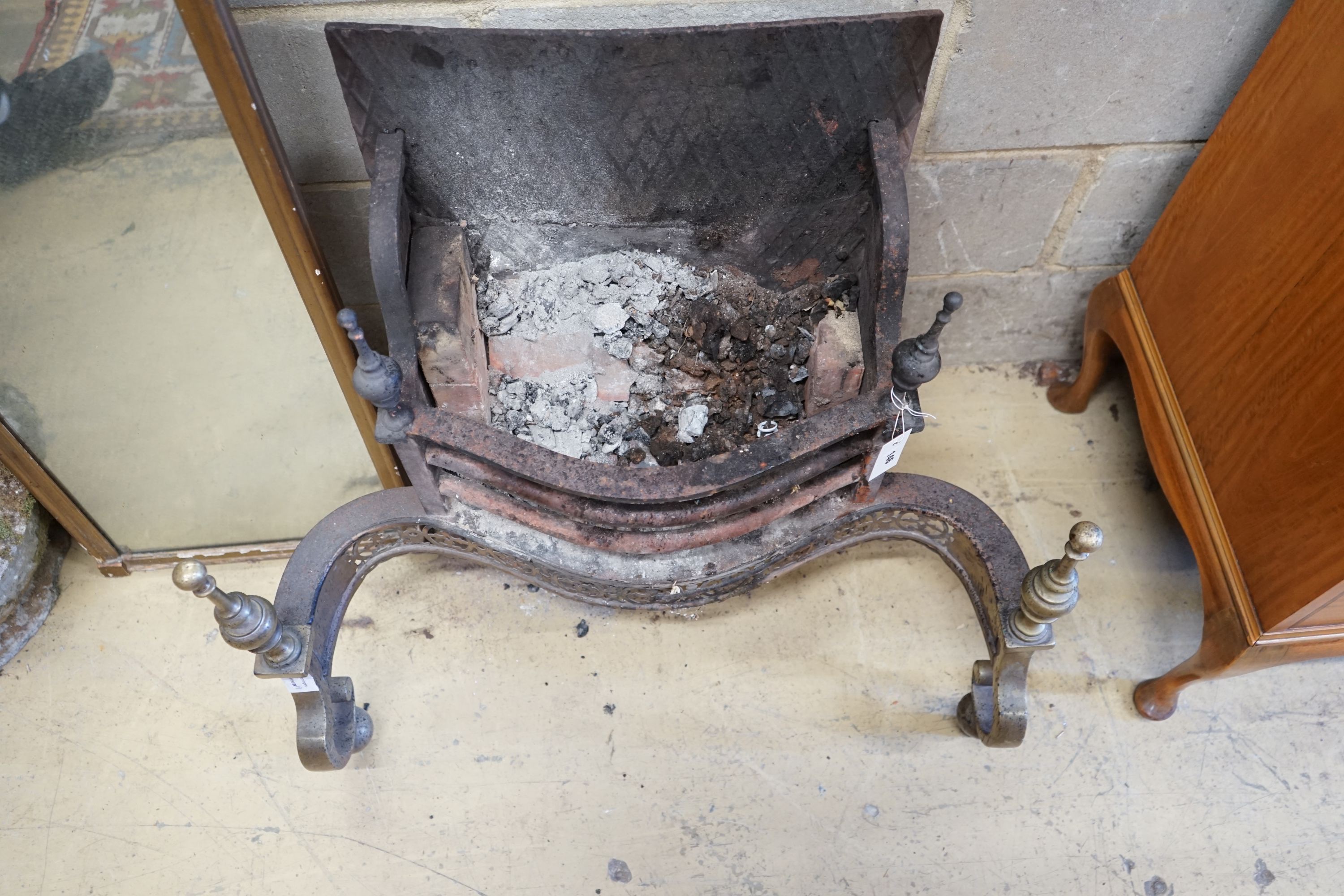 A Victorian brass mounted cast iron serpentine fire grate, width 80cm, depth 46cm, height 72cm